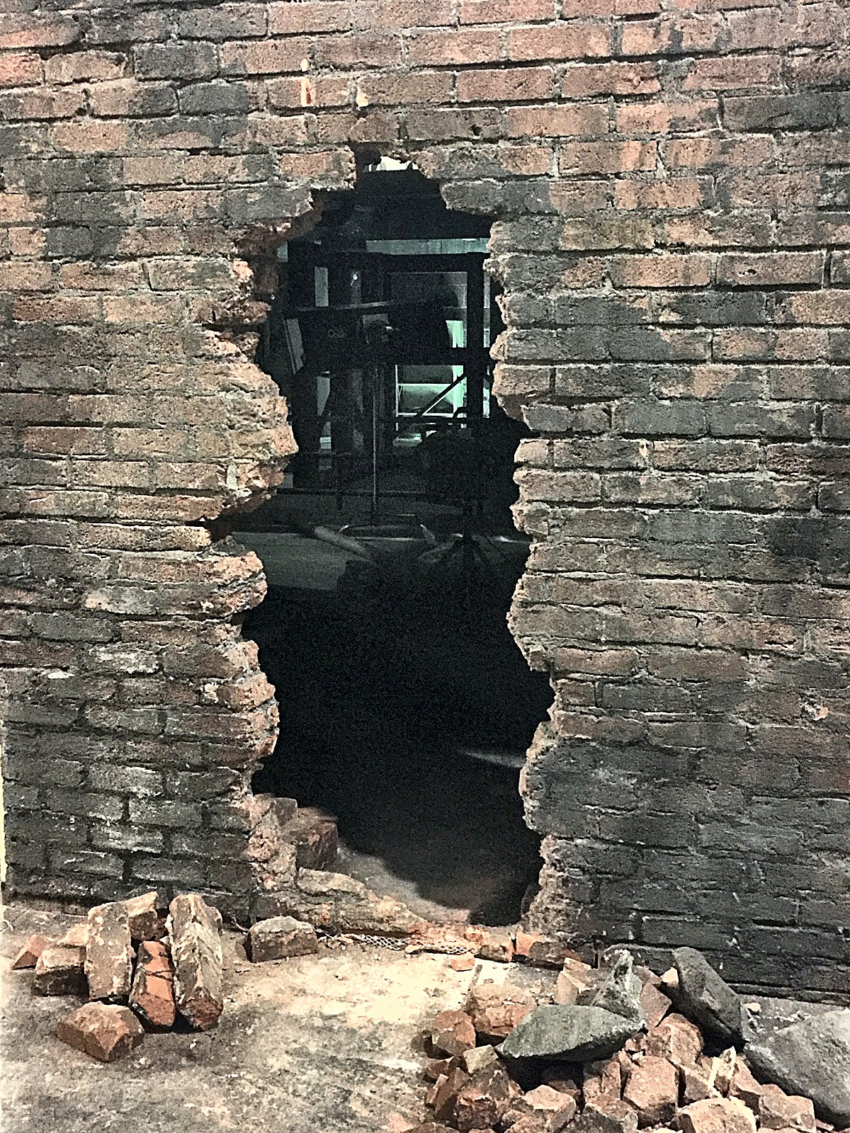 Broken plaster revealing aged brick beneath