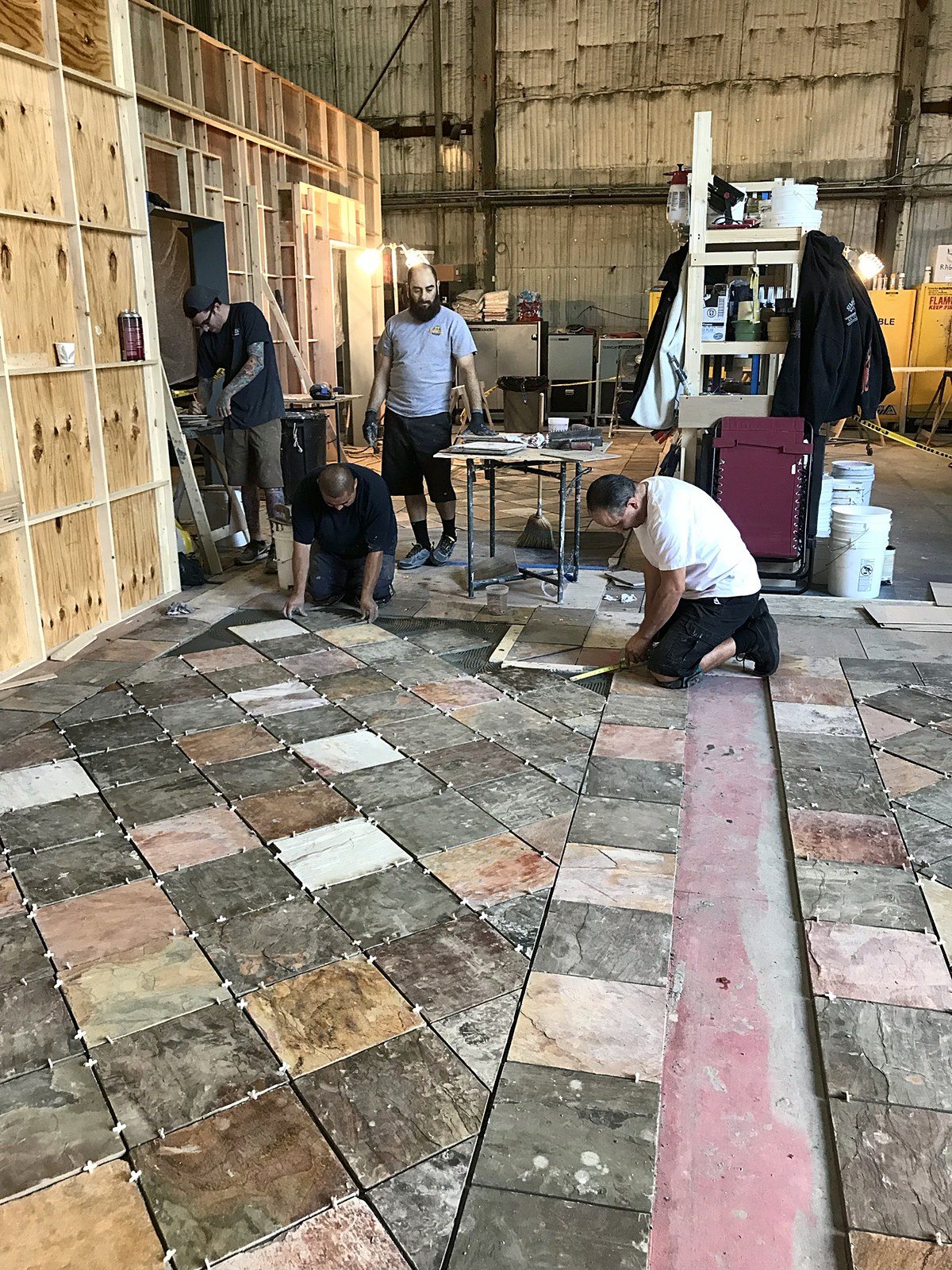 Crew hand-laying a slate tile floor